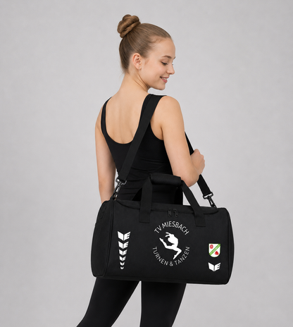 Frau die eine schwarze bedruckte Sporttasche von Erima trägt
