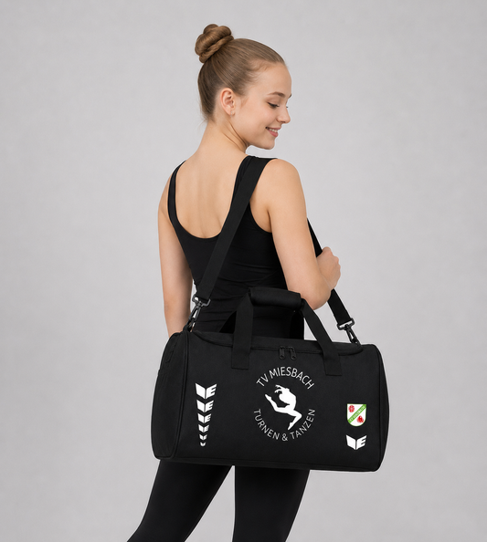 Frau die eine schwarze bedruckte Sporttasche von Erima trägt